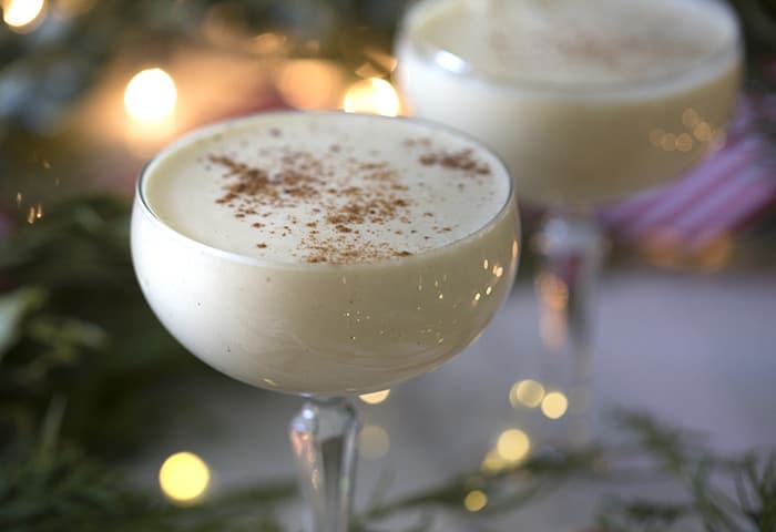 A closeup photo of eggnog cocktails in coupe glasses.