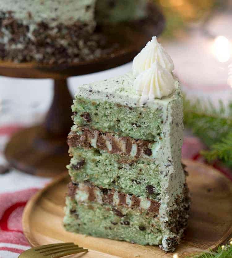 a piece of three layer mint chip cake on a wooden plate