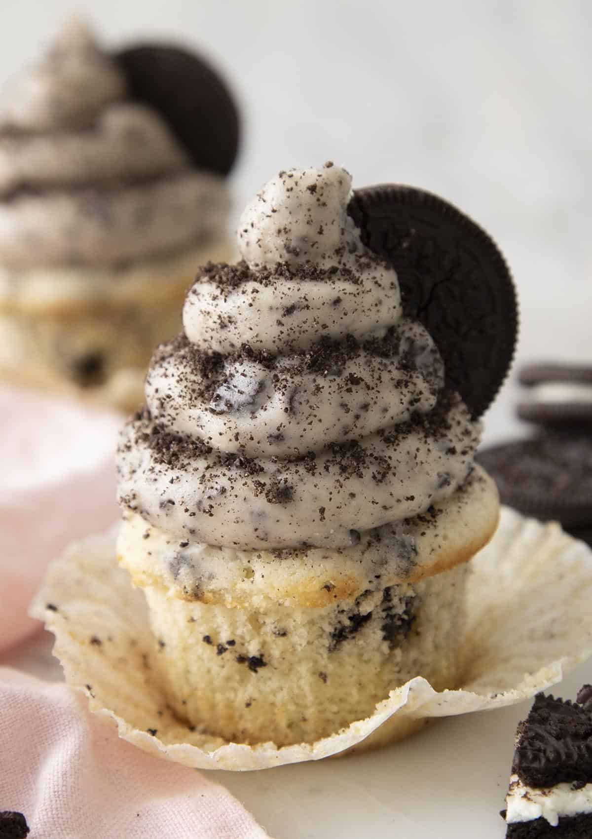 An Oreo cupcake topped with Oreo buttercream and crumbled Oreos.