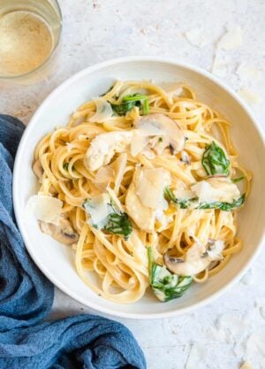 An overhead shot of artichoke pasta in a bowl with mushrooms and spinach