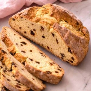 A loaf of Irish soda bread with a few slices cut.