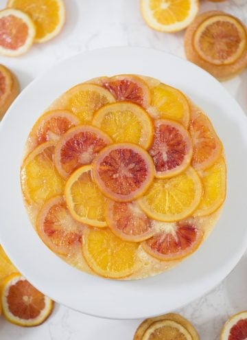 a top down photo of an orange upside down cake on a white cake strand