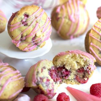 Raspberry muffins with one broken in half.