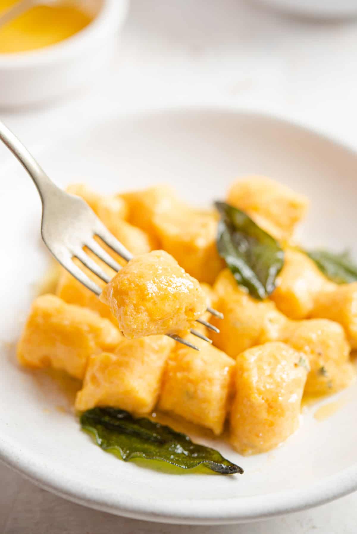 A close up of sweet potato gnocchi on a fork