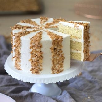 photo showing a striped coconut cake on a white cake stand