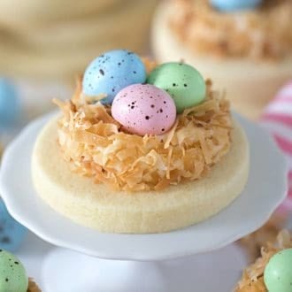 a sugar cookie with pastel chocolate eggs in a coconut nest.