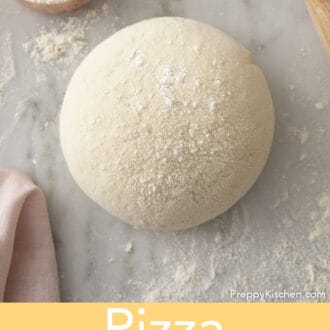 A ball of pizza dough on a marble table.