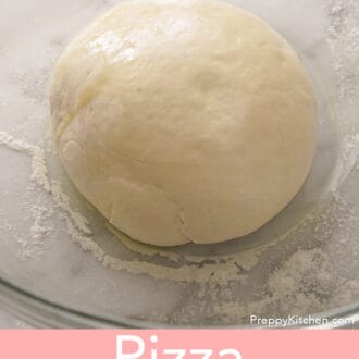 A ball of pizza dough in a glass bowl.