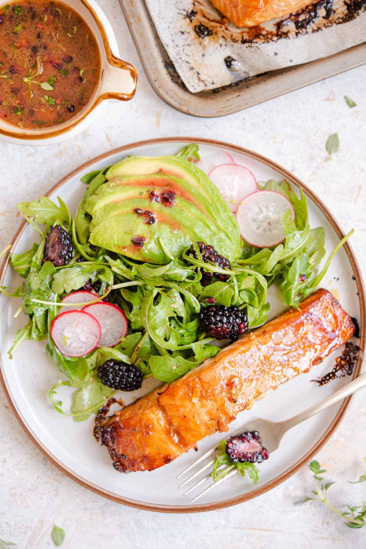 An overhead shot of glazed salmon on a plate with salad