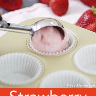 Strawberry cupcake batter going into a paper.