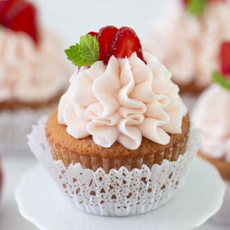 A delicious Strawberry cupcake with pink frosting.