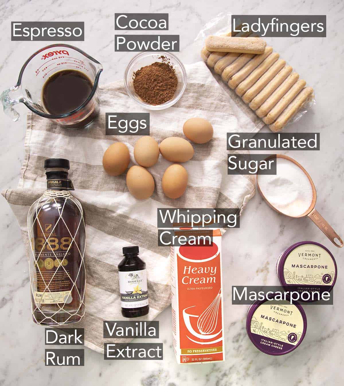 The ingredients needed to make tiramisu on a marble counter.