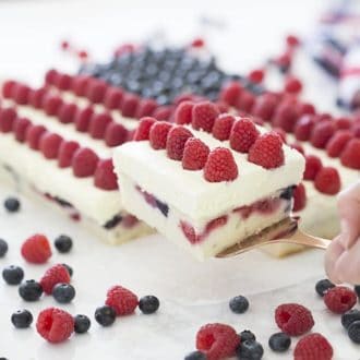 Photo of an American flag berry cake with a piece being removed.