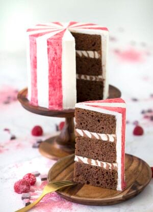 A photo of a chocolate beet cake with a slice on a wooden plate.
