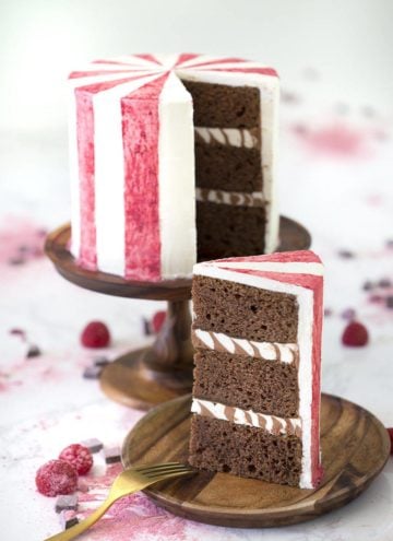 A photo of a chocolate beet cake with a slice on a wooden plate.