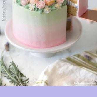 A pink to green ombre cake with orange and pink flowers and a piece out