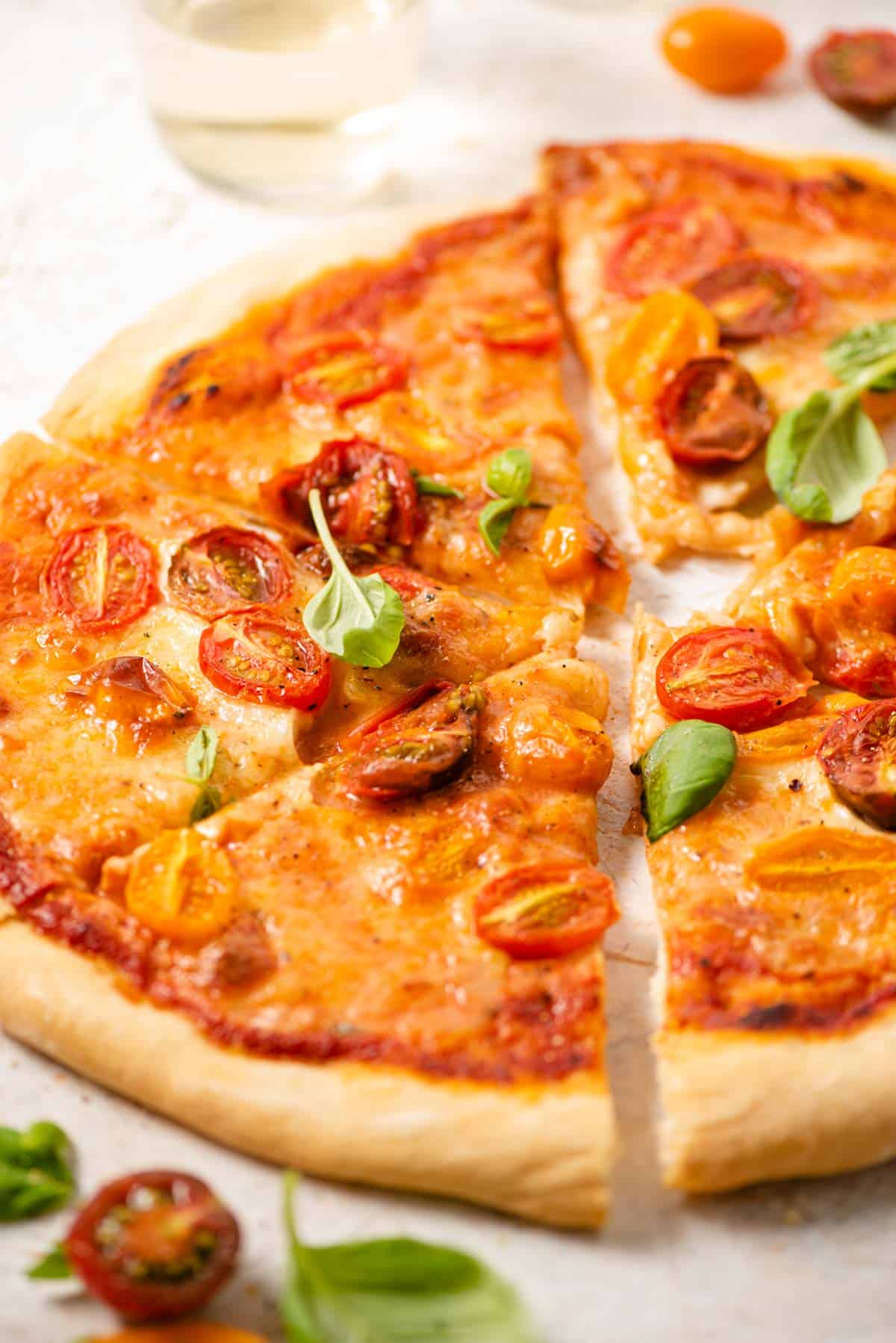 A close up of slices of pizza topped with cherry tomatoes and basil
