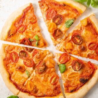 A square image of a tomato pizza cut into slices