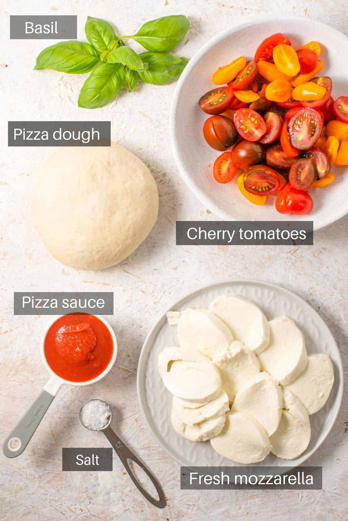 An overhead shot of a all the ingredients you need to make tomato pizza