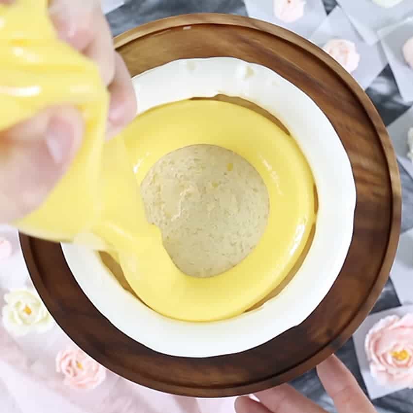 Photo of lemon curd being piped to fill a cake layer