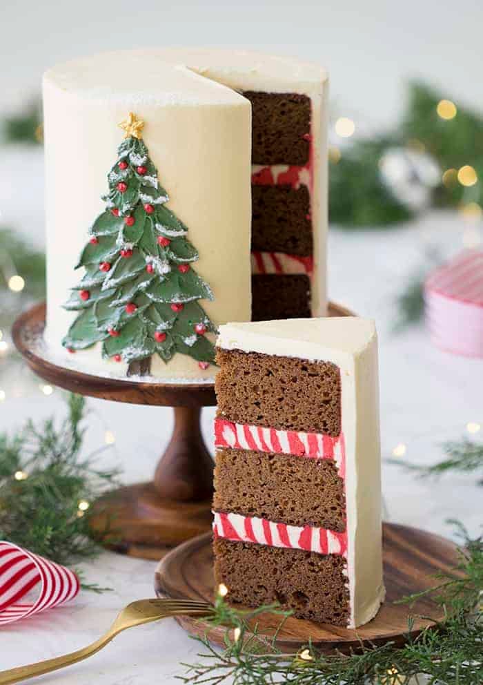 A photo of a gingerbread cake with a painted Christmas tree made from butter cream on the front.
