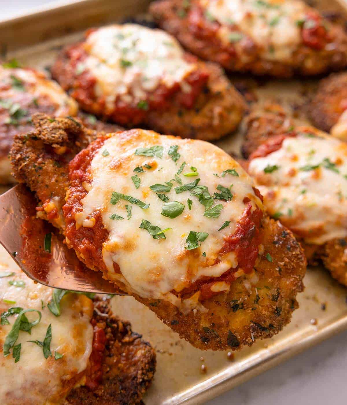A close up of chicken parmesan on a baking tray