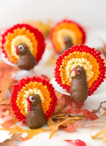 A photo of a group of cupcakes with buttercream turkeys piped onto them