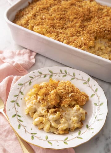 A plate of baked mac and cheese next to a baking dish.