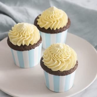 A photo of three cupcakes topped with french buttercream