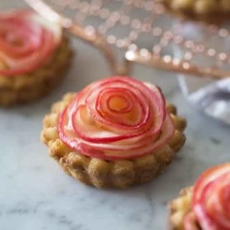 An apple rose tart on a white marble table