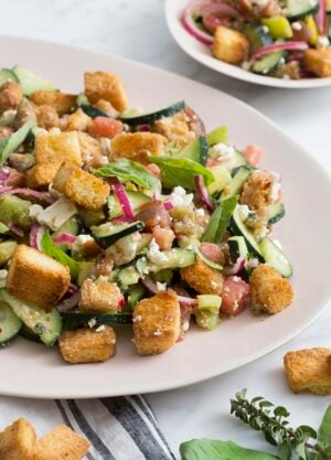 A photo of a panzanella salad on a serving plate.