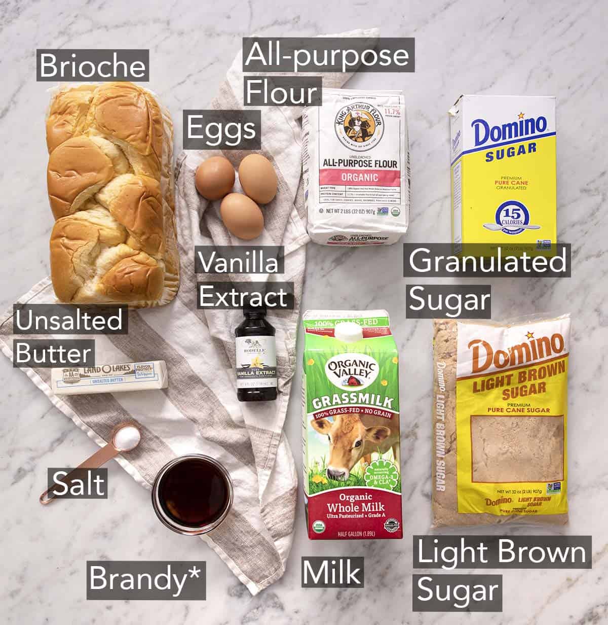 Ingredients to make Bread Pudding on a marble counter.