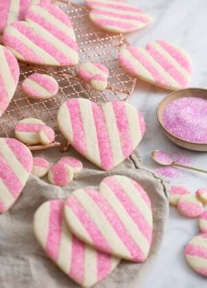 A photo showing a group of striped pink and white Valentine's Day Heart Cookies on a white marble surface