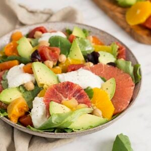 A photo of a colorful avocado salad with oranges and greens