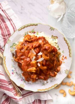 Butter chicken on a plate garnished with coconut.