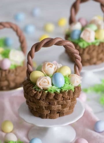 A cupcake that looks like an easter basket filled with flowers and eggs