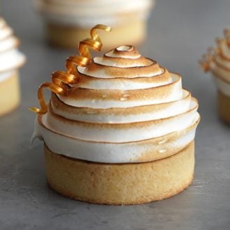 A chocot showing a chocolate tart topped with a perfect spiral of toasted meringue and a sugar corkscrew