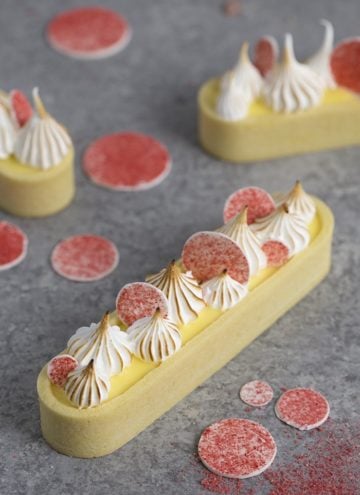 A photo showing a lemon curd tart topped with toasted meringue dollops