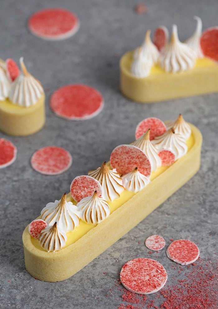 A photo showing a lemon curd tart topped with toasted meringue dollops