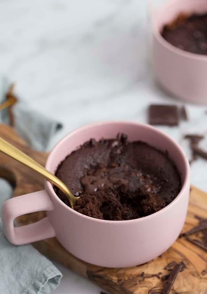 A photo of a chocolate cake in a pink coffee mug