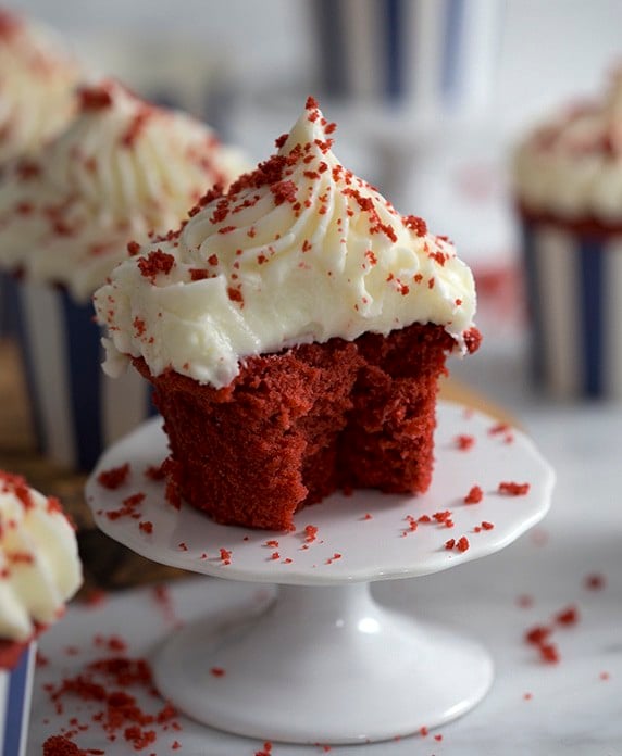 A red velvet cupcake with a bite taken out.