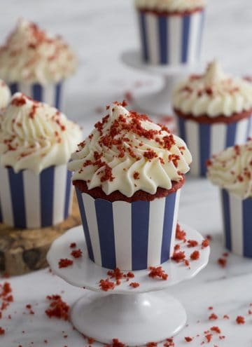 A photo of a group of red velvet cupcakes with a big dollop of cream cheese frosting.