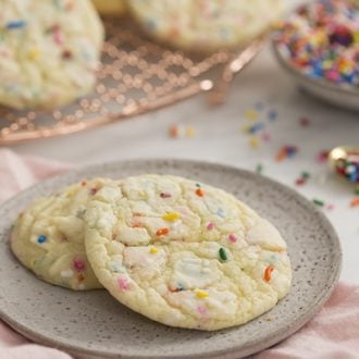 A photo od cake mix cookies that have sprinkles in them on a white marble table.