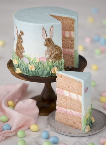 a photo showing two Easter bunnies painted in buttercream on a cake.
