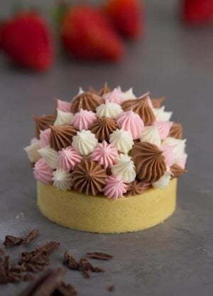 A photo of a Neapolitan tart with different sized dollops of Swiss meringue buttercream piped on top.