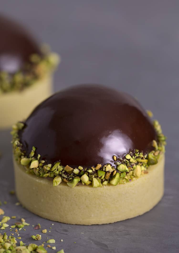 A pistachio tart topped with a chocolate dome