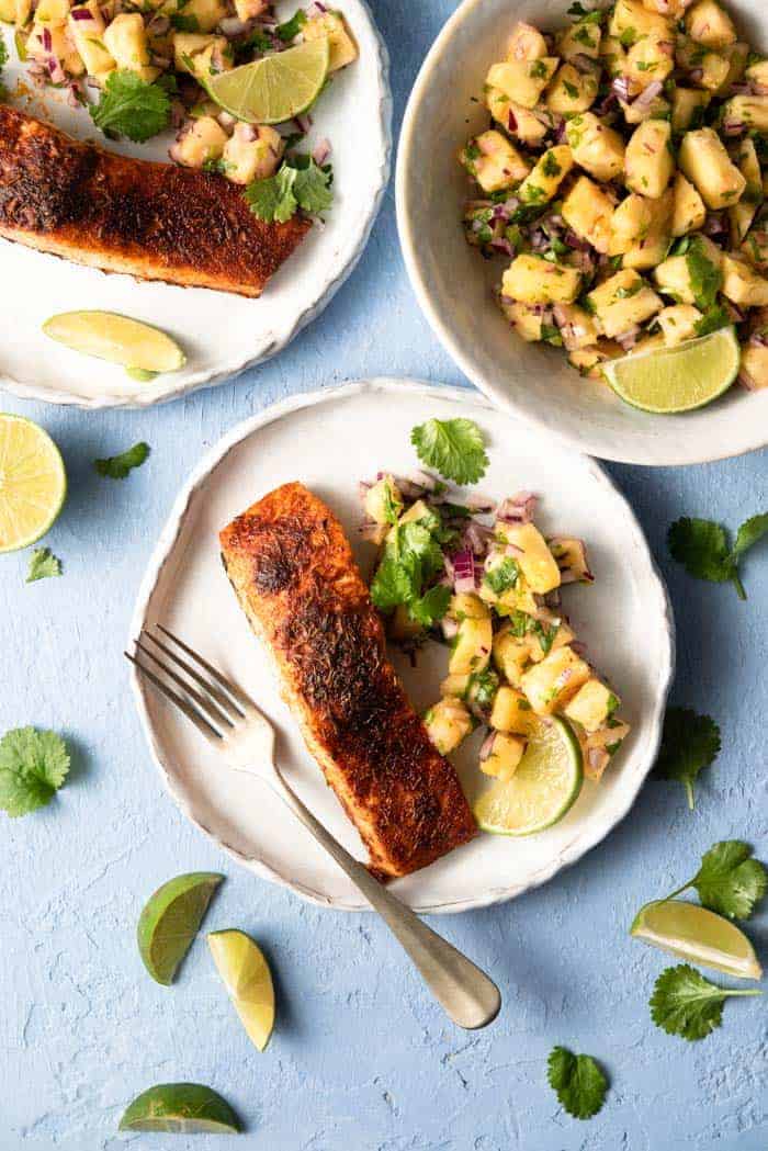 An overhead shot of blackened salmon on a plate with pineapple salsa