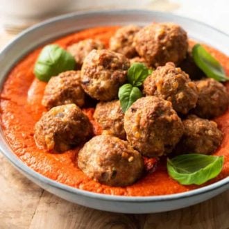 A close up of turkey meatballs in a bowl with smoky marinara sauce