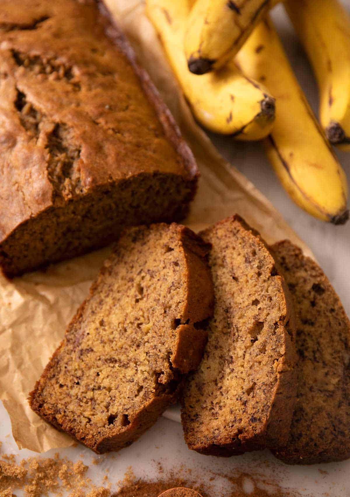 A close up of a loaf of banana bread with some slices cut