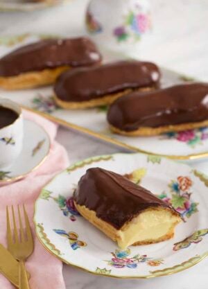 A photo of a chocolate eclair cut to expose the custard filling